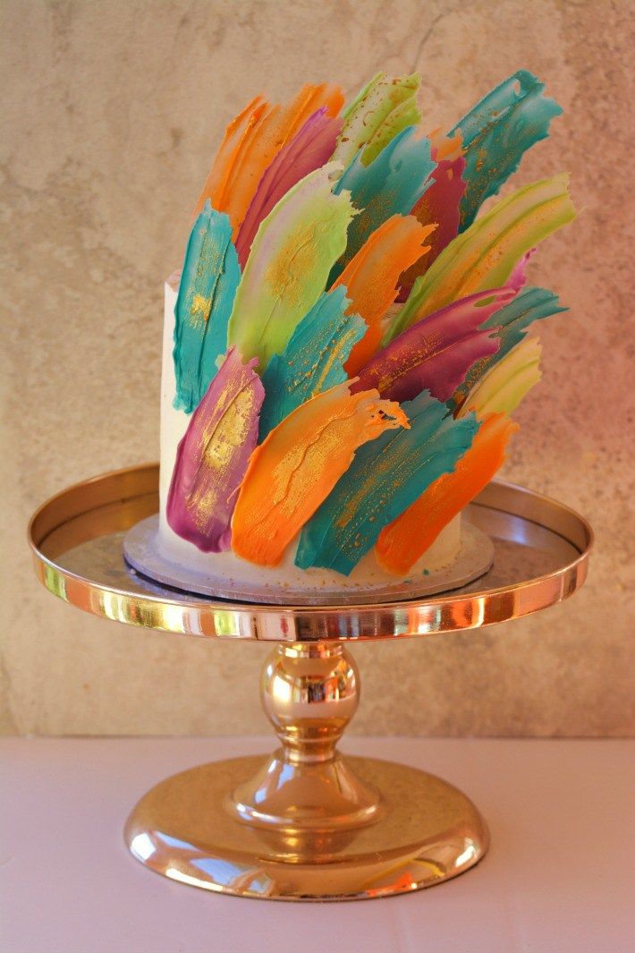 there is a cake with colorful feathers on it