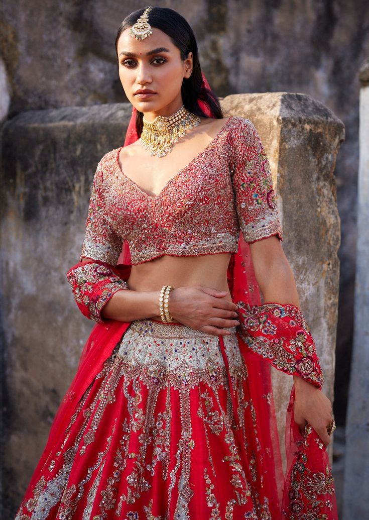 Red raw silk bridal lehenga with thread and zardosi embroidery with a tulle dupatta and a tulle head veil. Embroidered blouse. Red Raw Silk Set With Sheer Dupatta, Red Hand Embellished Sharara For Wedding, Red Hand-embellished Sharara For Wedding, Hand Embellished Red Sharara For Wedding, Red Hand Embellished Wedding Gown, Hand Embellished Red Wedding Gown, Hand Embellished Sharara For Traditional Ceremonies, Hand Embellished Traditional Sharara For Ceremonies, Red Raw Silk Choli For Wedding