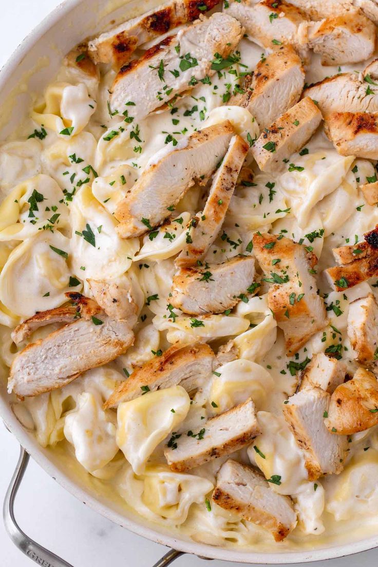 chicken alfredo in a skillet with parsley on top