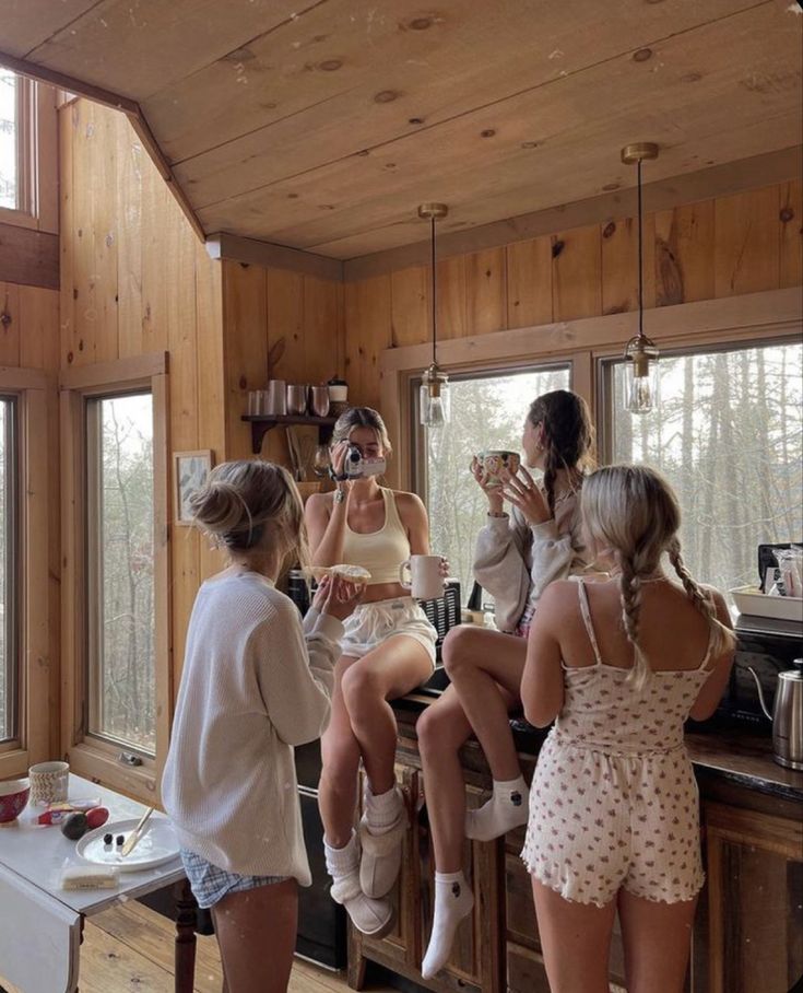 three women are sitting on the counter in a cabin