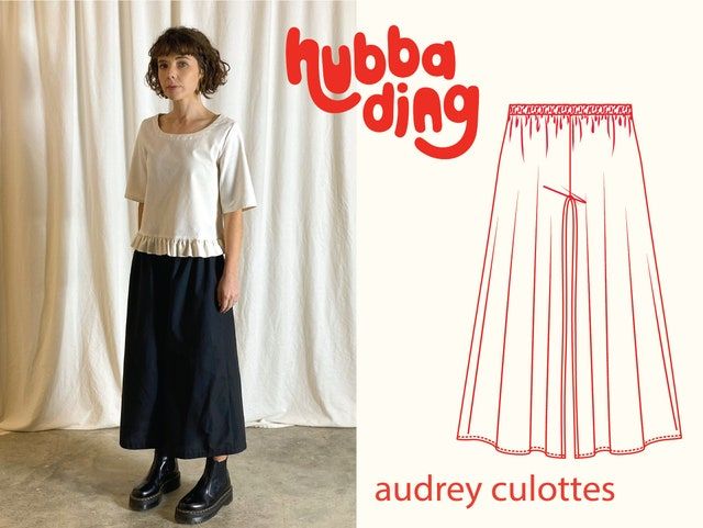 a woman standing in front of a white curtain with the words hubba ding on it