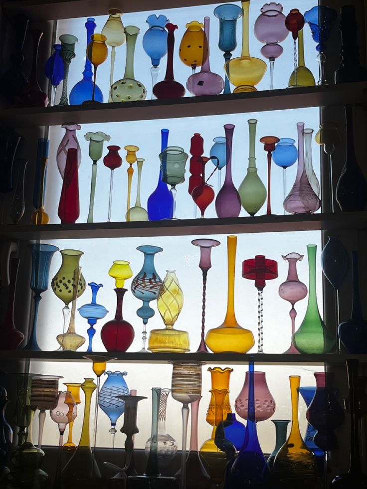 many different colored glass vases are on display