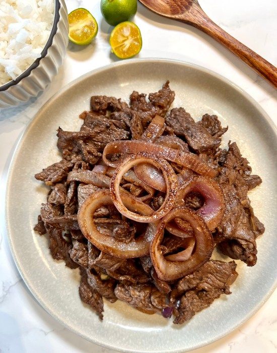 a white plate topped with meat and onions