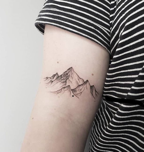 a woman with a mountain tattoo on her arm