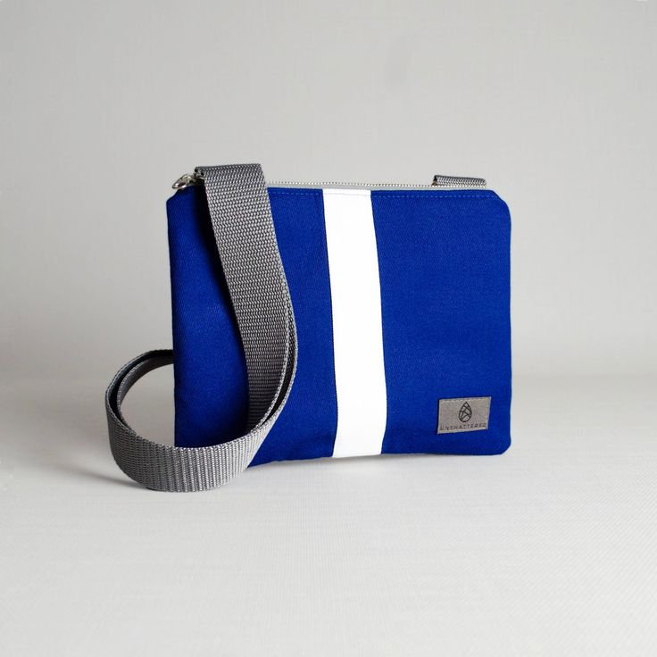 Our crossbody pouch now comes in a stunning blue and white pattern! With a slim profile that expands to hold your keys, phone, card holder and more, this pouch is classic and functional. Upcycled like all of our bags, this crossbody pouch was handcrafted by a woman in recovery and was uniquely designed from a pair of pants worn by the West Point Concert/Marching Band and the Hellcats field music group. Purchase this upcycled, crossbody pouch and create possibilities for women on our team to sust Blue Shoulder Phone Bag For On-the-go, Blue Rectangular Phone Bag With Removable Pouch, Modern Blue Shoulder Bag With Cell Phone Pocket, Blue Rectangular Phone Bag With Adjustable Strap, Blue Phone Bag With Cell Phone Pocket For On-the-go, Functional Blue Phone Bag With Cell Phone Pocket, Rectangular Blue Phone Bag For Daily Use, Versatile Blue Phone Bag For Travel, Blue Travel Pouch Phone Bag