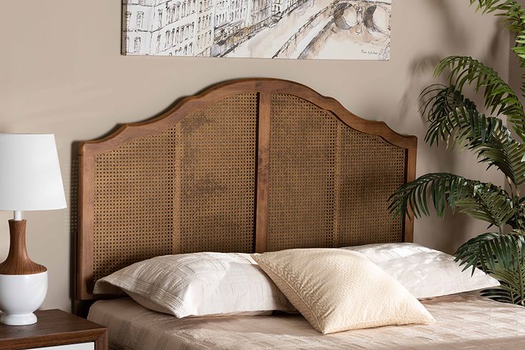 a headboard made out of wicker with pillows on it and a plant in the corner