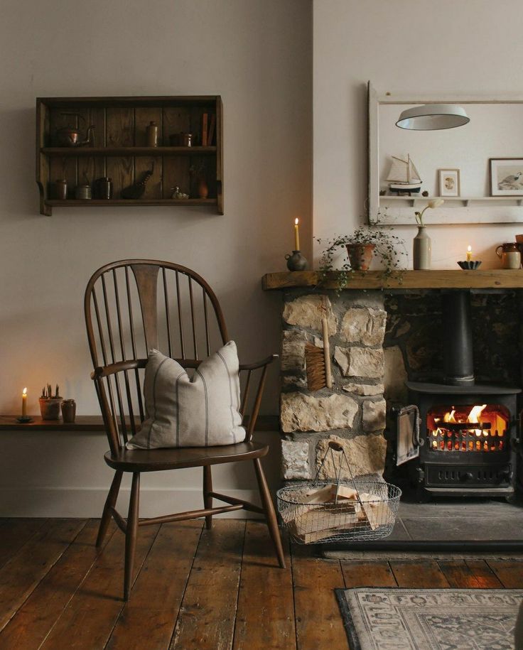 a living room with a fire place next to a chair and rug on the floor