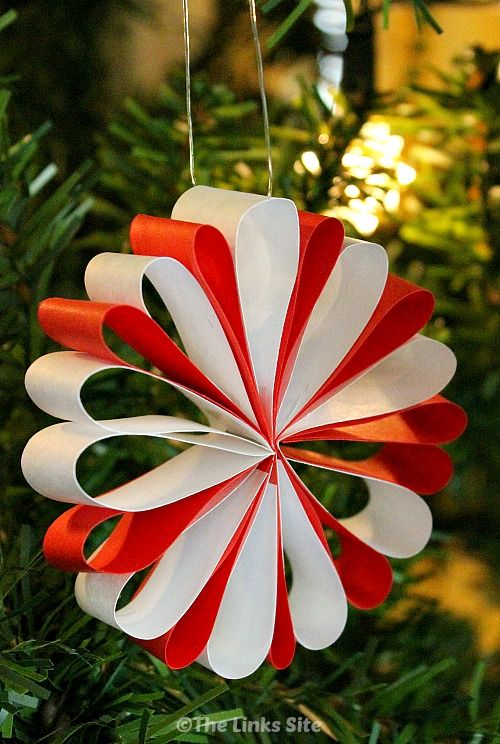 a red and white ornament hanging from a christmas tree