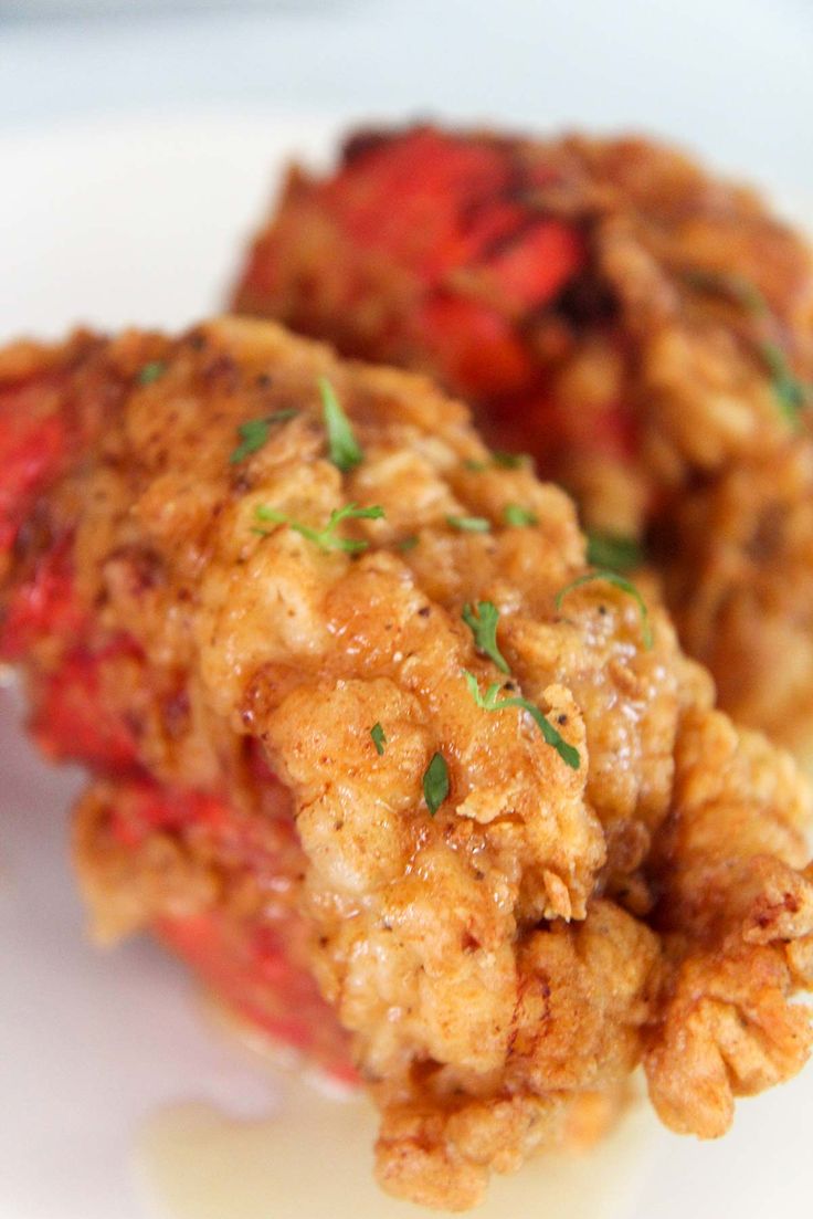 two pieces of fried food on a plate with parsley sprinkled on top