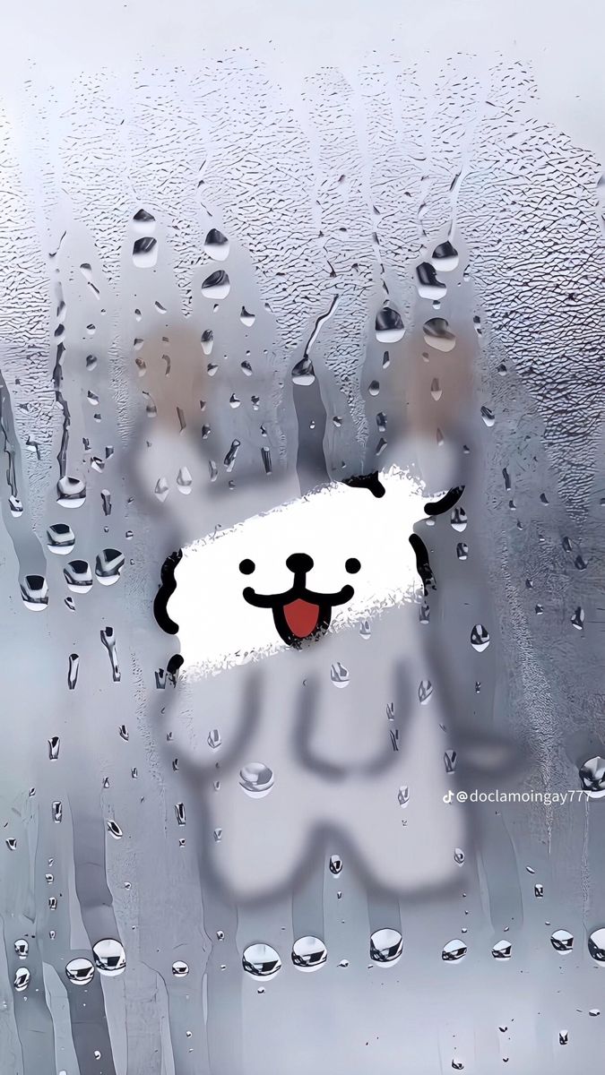 a white teddy bear sitting on top of a window covered in raindrops with its mouth open