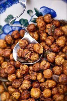 a spoon full of nuts sitting on top of a blue and white plate