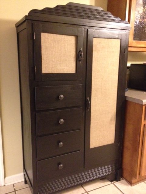 an armoire in the corner of a kitchen