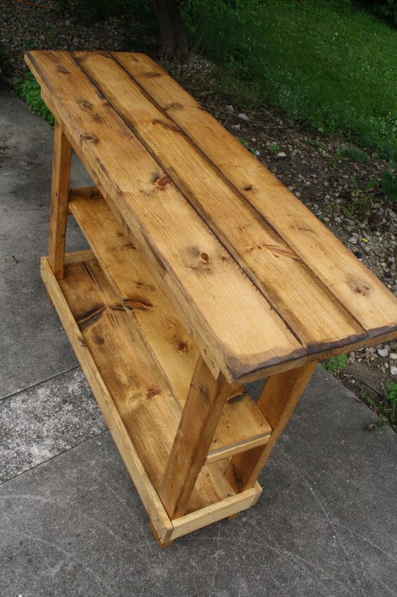 a wooden bench sitting on top of a cement ground next to a grass covered field