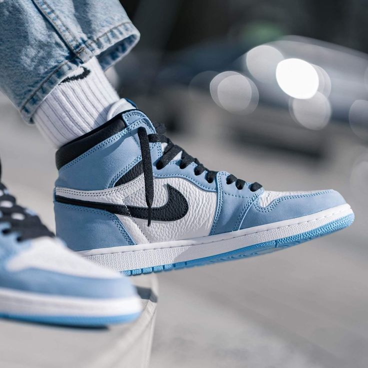 The Air Jordan 1 Retro High OG ‘University Blue’ makes use of a familiar palette that gives the nod to Michael Jordan’s UNC alma mater. The all-leather upper features a white base with powder blue overlays and a black signature Swoosh. Matching black accents make their way to the collar, tongue tag and printed Wings logo on the lateral collar flap. A brighter shade of blue is applied to the standard AJ1 outsole, featuring multi-directional traction and a pivot point under the forefoot. Fake Shoes, Air Jordan 1 Outfit, Jordan Shoes Girls, Blue Jordans, Air Jordan Sneakers, Air Jordan 1 Retro High Og, Air Jordan 1 Retro High, Air Jordan 1 High, Jordan 1 High