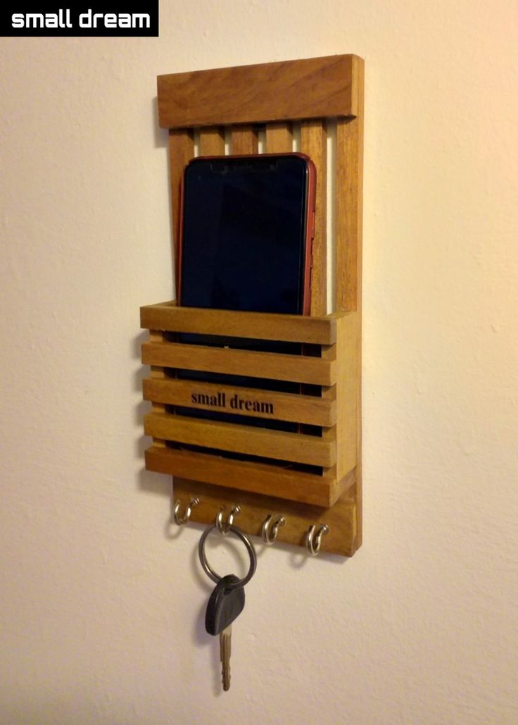 a wooden cell phone holder with keys hanging from it's sides and the words small dream written on it