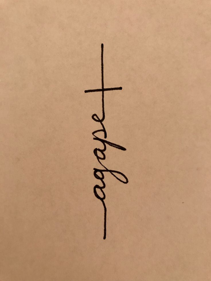 the word jesus written in cursive ink on a piece of paper with a cross