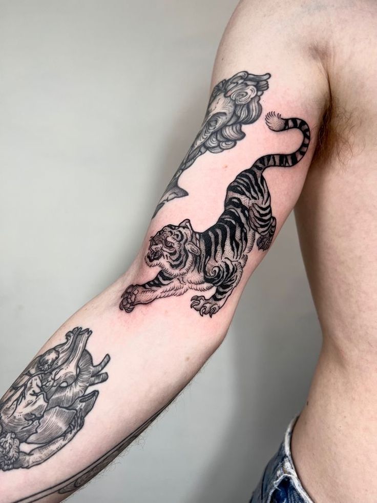 a man with a tiger tattoo on his arm