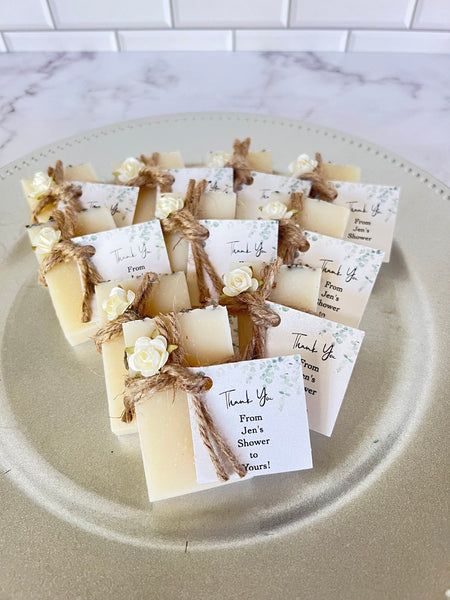 several pieces of soap on a plate with some tags attached to the top of them