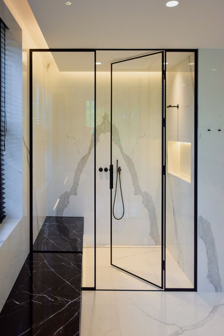 a bathroom with marble flooring and walls, along with a walk - in shower