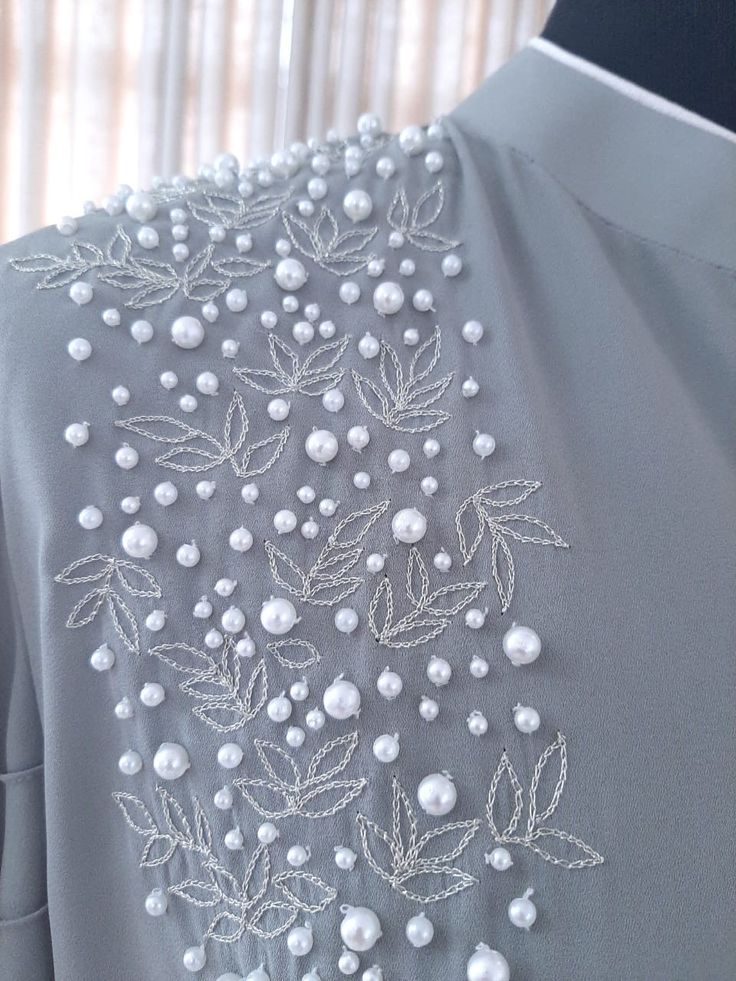 the back of a dress with pearls on it