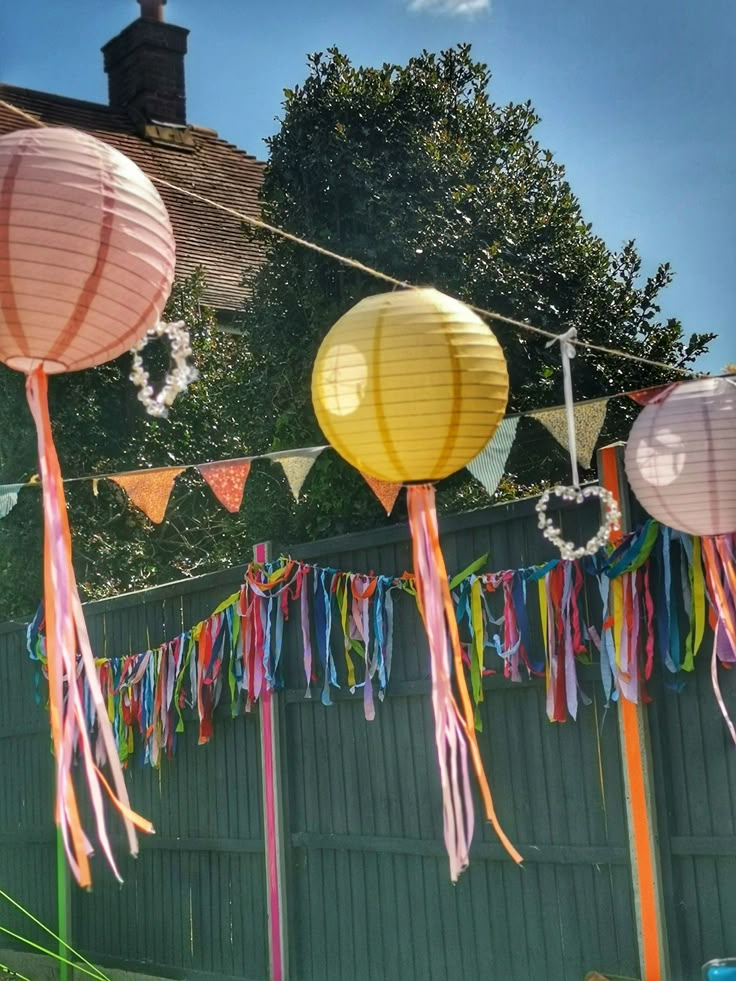 some paper lanterns hanging from a line with streamers