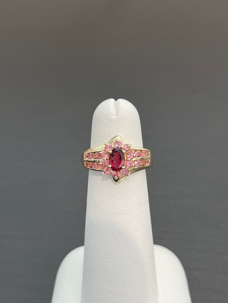 This GORGEOUS ring is ALL GENUINE TOURMALINE! The center is a 6 x 4.2 mm rubellite tourmaline with a rich color that draws you in. It is surrounded by 22 pink tourmalines and set in 14K yellow gold. FABULOUS gift for someone who loves pink or has a significant day in October. Tourmaline and opal are the gems for October. Ruby Birthstone Ring With Pink Center Stone, Formal Multi-stone Tourmaline Ruby Ring, Red Tourmaline Fine Jewelry Rings, Red Tourmaline Rings Fine Jewelry, Formal Multi-stone Ruby Ring With Tourmaline, Oval Pink Tourmaline Ruby Ring, Fine Jewelry Red Tourmaline Rings, Pink Tourmaline Birthstone Ring, Tourmaline Ruby Ring With Accent Stones For Promise