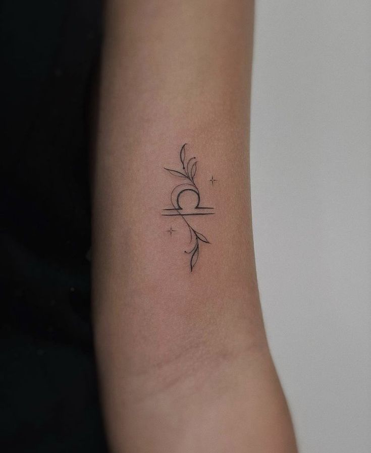 a woman's arm with a small tattoo design on the left side of her arm