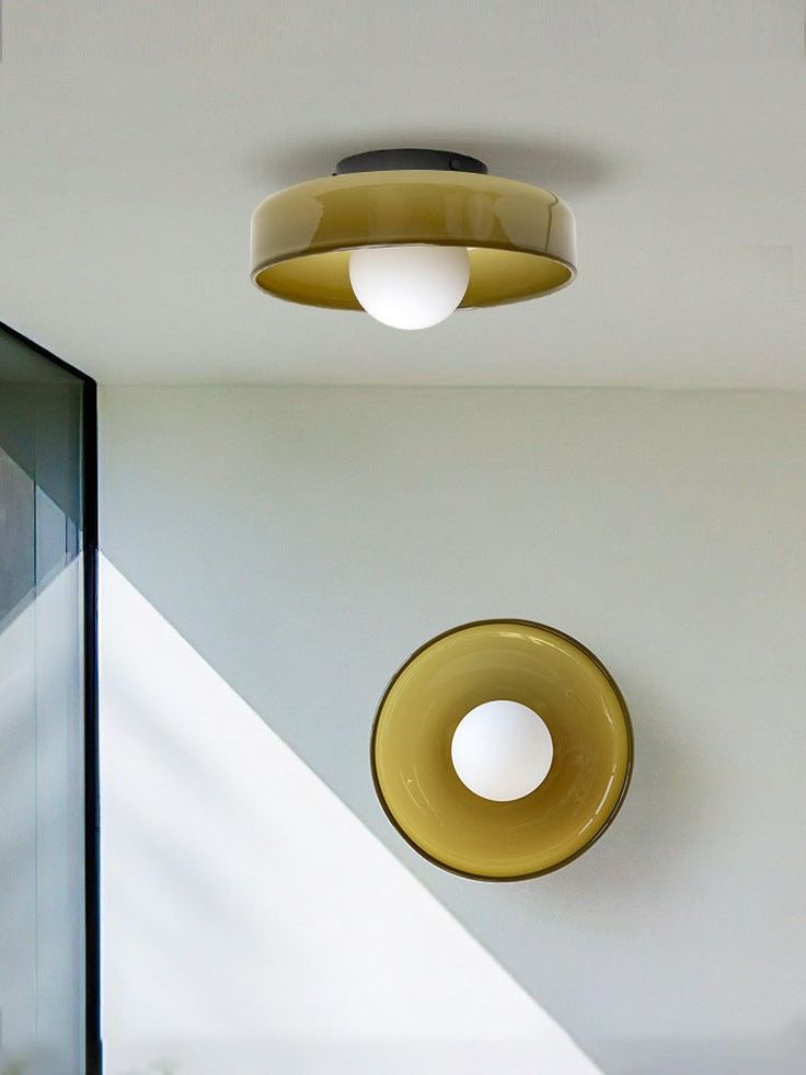 two circular lights hanging from the ceiling in a room with white walls and flooring