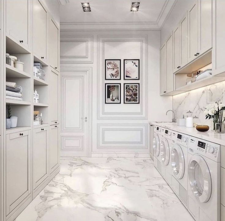 a white laundry room with marble floors and walls