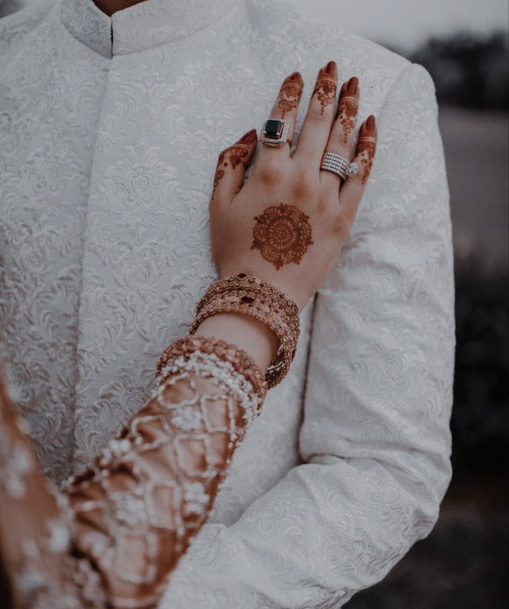 a bride and groom holding each other's hands with their wedding rings on them