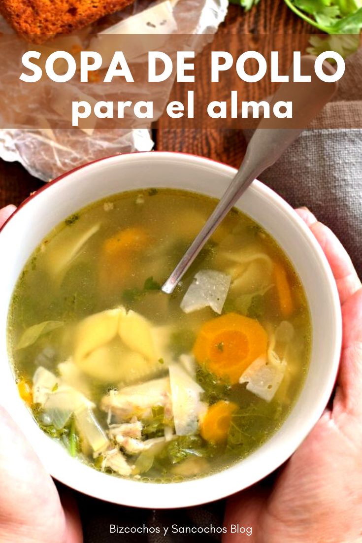 two hands holding a bowl of soup with bread in the background and text overlay that reads sopa de pollo para el alma