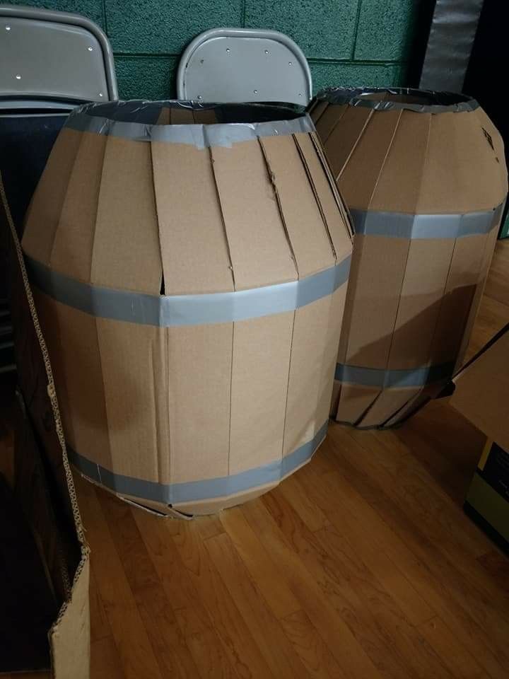 two cardboard barrels sitting on top of a hard wood floor