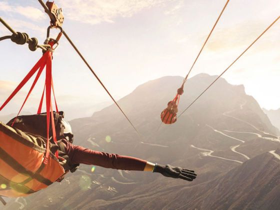 two people are suspended in the air by ropes with their hands and feet dangling from them