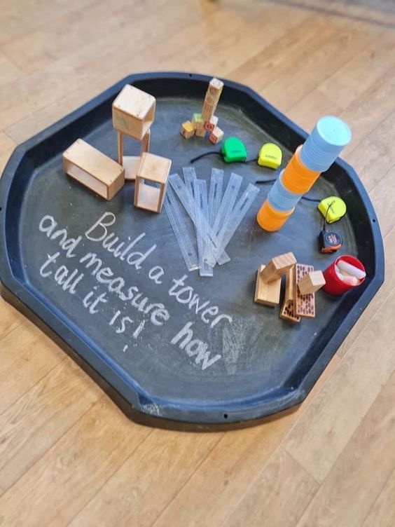 a child's chalkboard with wooden toys on it