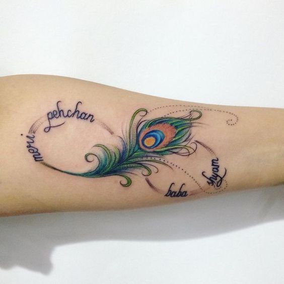 a peacock feather tattoo on the arm with words written in cursive writing and an arrow