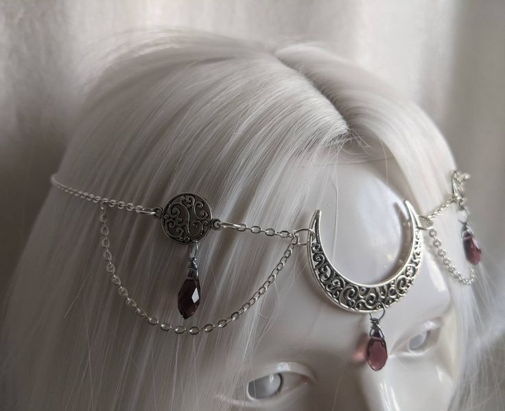 A gorgeous head chain featuring a bronze filigree moon and two filigree circle charms, each with a dangling glass bead. Perfect for renaissance fairs, weddings, cosplay, or any event of your choosing! Fits head circumferences from 21 inches to 24.5 inches. Bohemian Metal Dangle Body Jewelry, Bohemian Moon Charm Jewelry For Party, Bohemian Moon Jewelry For Party, Elegant Moon Phase Jewelry For Festivals, Bohemian Moon-shaped Jewelry For Party, Elegant Moon Phase Festival Jewelry, Bohemian Moon-shaped Party Jewelry, Elegant Metal Jewelry With Sun And Moon Design, Elegant Sun And Moon Design Metal Jewelry