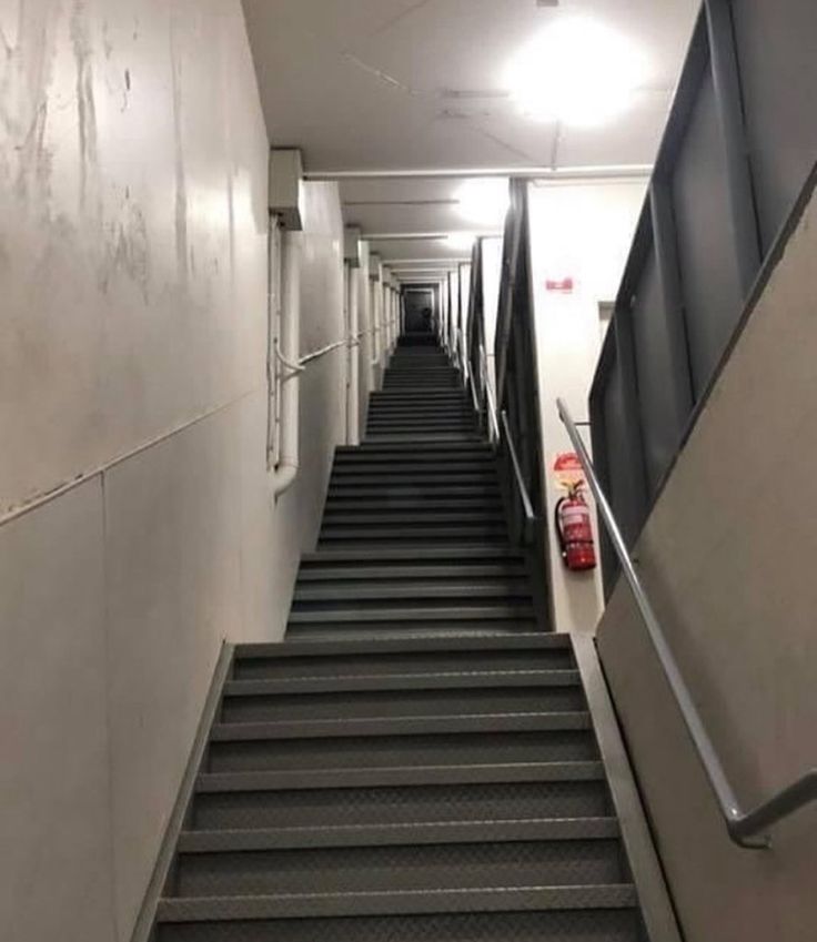 the stairs lead up to the second floor in an apartment building with no people on them