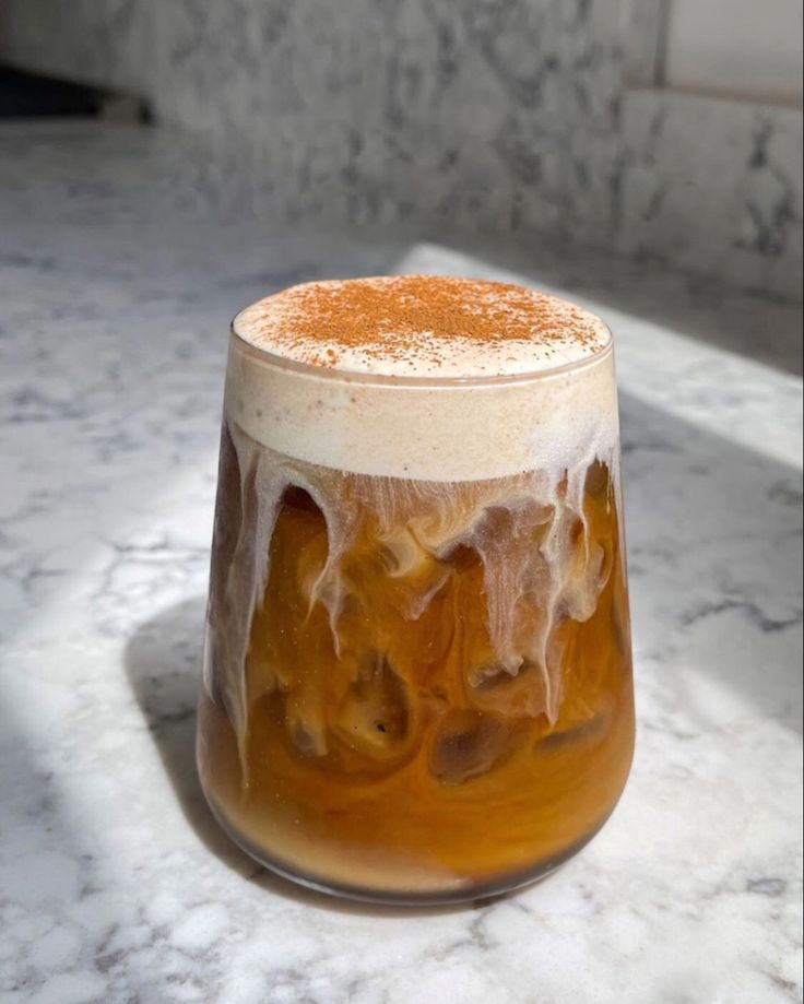 a glass filled with liquid sitting on top of a counter