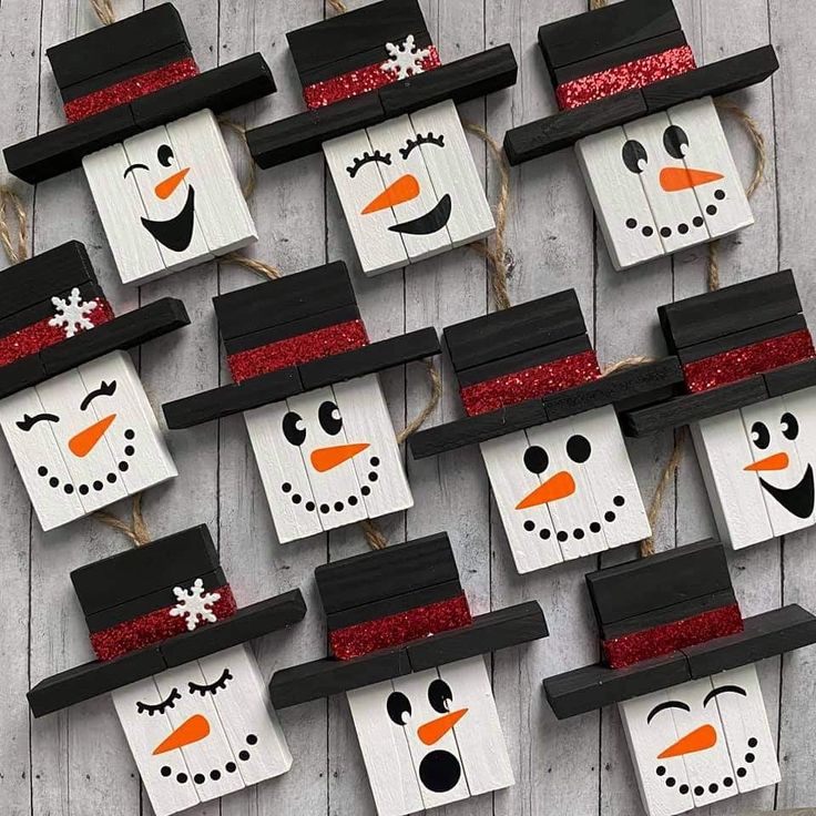 snowmen made from wood planks are hanging on the side of a wooden wall