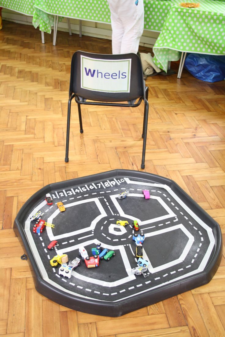 a child's play area with toys on the floor and a sign that says wheels