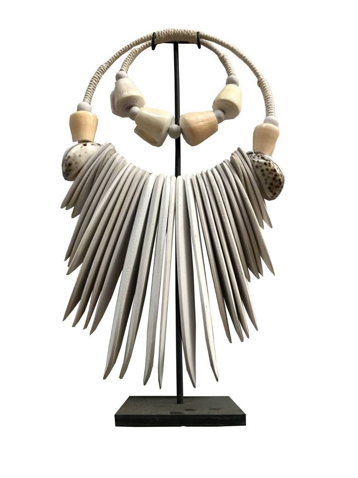 Handmade ceremonial Papua traditional Ornament from Indonesia. Made of white Shells . This Necklace is used in Papua for special rituals or ceremonies. Also is used as a payment between tribes. This beautiful piece is a very unique and powerful object in the Balinese culture. Size : Width 28 cm x 48 cm high Stature on its stand : 48 cm It can be wearied or used as a Decoration. You can buy with black metal stand You can buy without stand, you can hang it on the wall. Traditional Handmade White Necklace, Traditional White Handmade Necklace, Artisan White Necklaces For Festivals, Handmade White Jewelry For Traditional Ceremonies, White Artisan Jewelry For Festivals, Artisan White Jewelry For Festivals, Traditional Jewelry With Natural Wooden Beads, Traditional Natural Jewelry For Rituals, Traditional White Fair Trade Necklaces