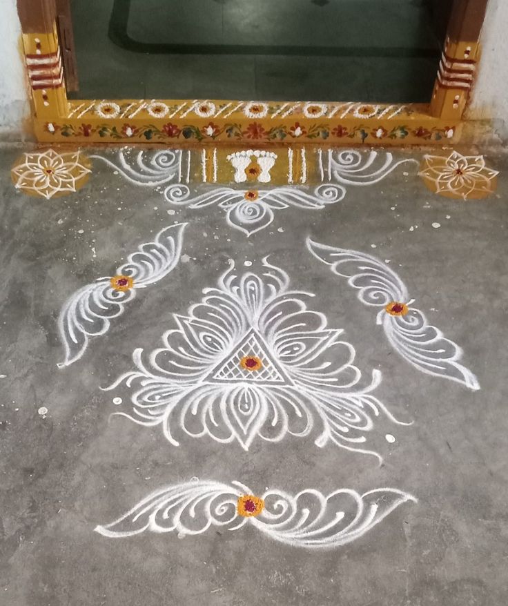 an intricately painted floor in front of a door with flowers and leaves on it