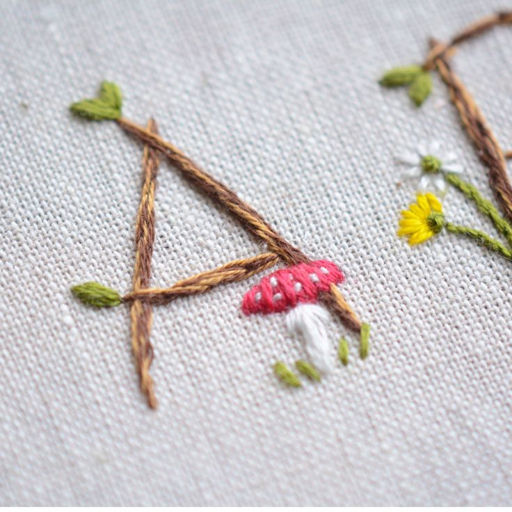 the embroidery is stitched together with twigs and flowers on it's side,