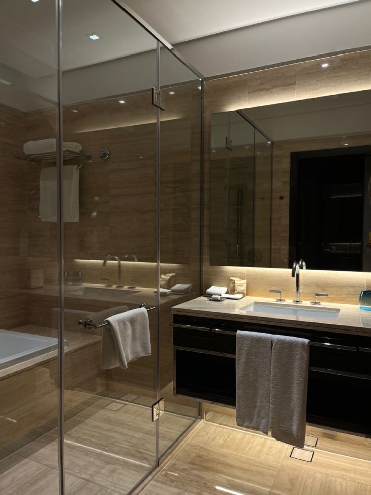 a bathroom with a glass shower door, sink and bathtub in the middle of it