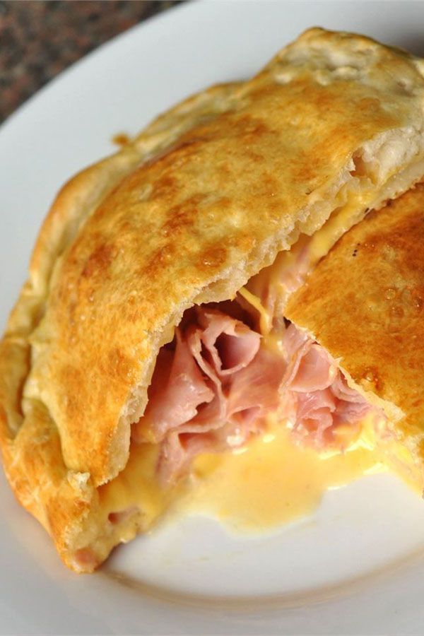 a ham and cheese pastry on a white plate