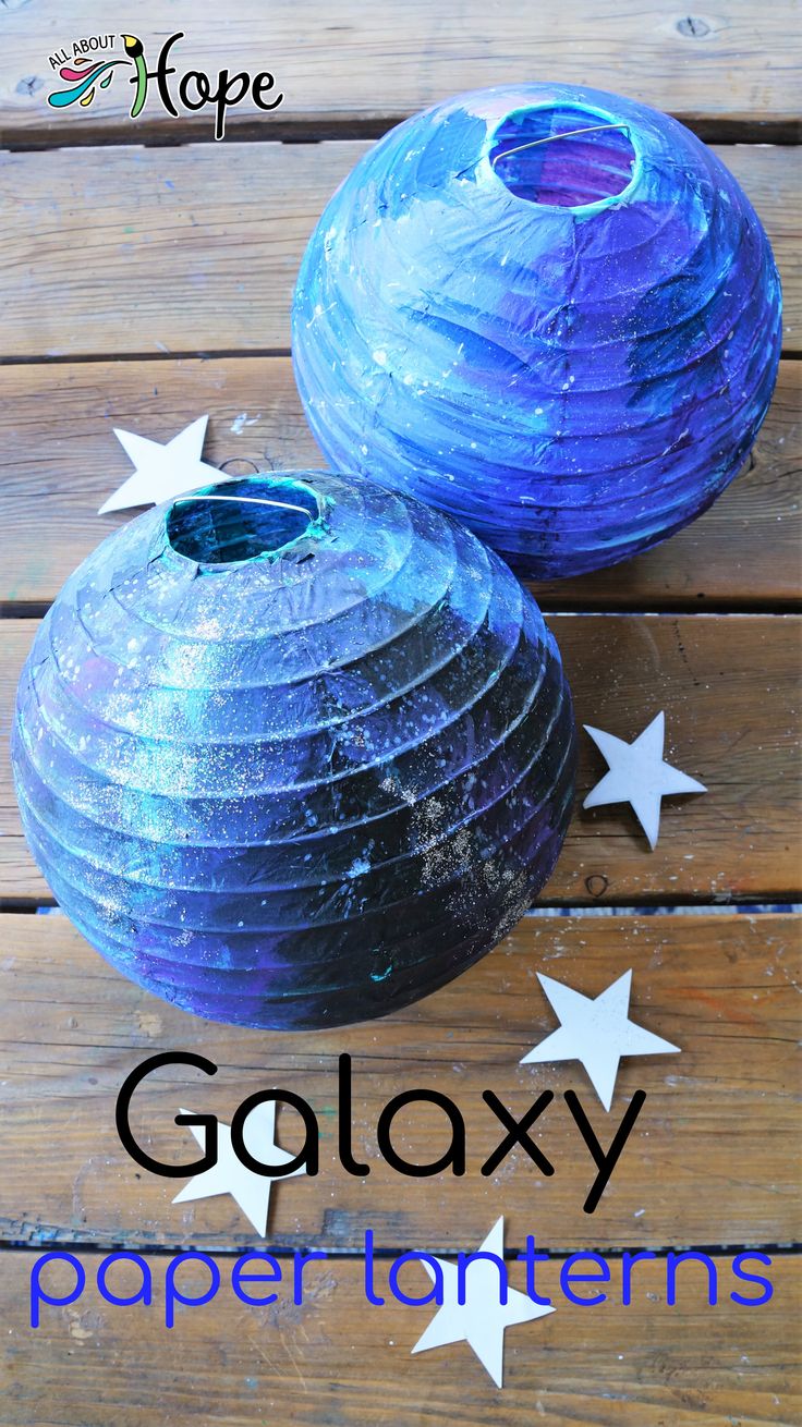 two blue vases sitting on top of a wooden table with the words galaxy paper lanterns