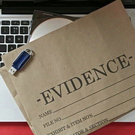 a piece of paper with the word evidence on it next to a computer keyboard and mouse