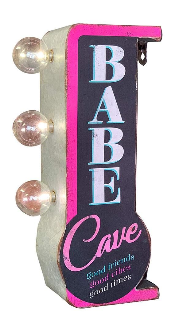 a sign that says babe cave hanging from the side of a building with three lights on it