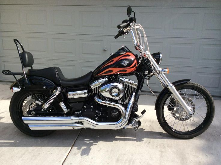 a black and red motorcycle parked in front of a garage