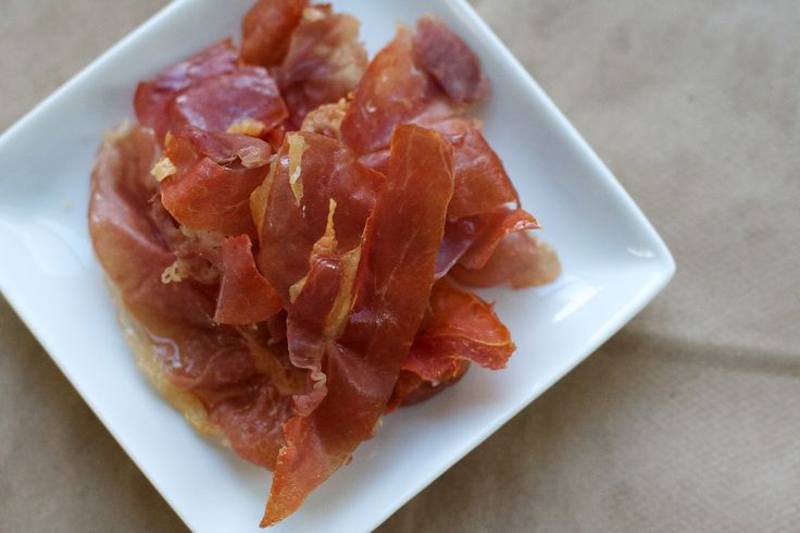 bacon on a square white plate sitting on a table